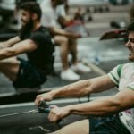 Focused athletes engaged in a high-intensity rowing session in the gym, showcasing strength and endurance.